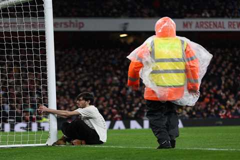 Arsenal’s clash against Liverpool stopped after pitch invader HANDCUFFS himself to goal post