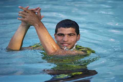 Watch tennis star Carlos Alcaraz dive into pool along with screaming ball girls after winning..